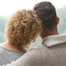 Two people hugging on a bench