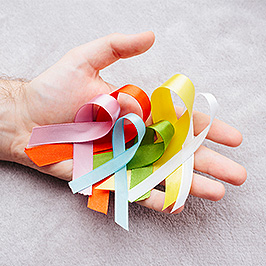 Open hand holding several coloured ribbons